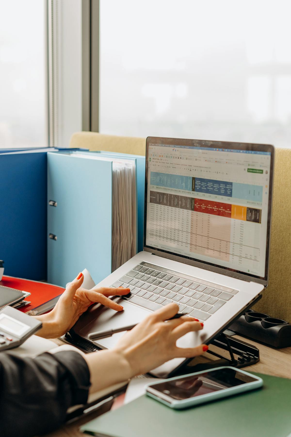 A laptop screen with analytics open beside paperwork on a desk.